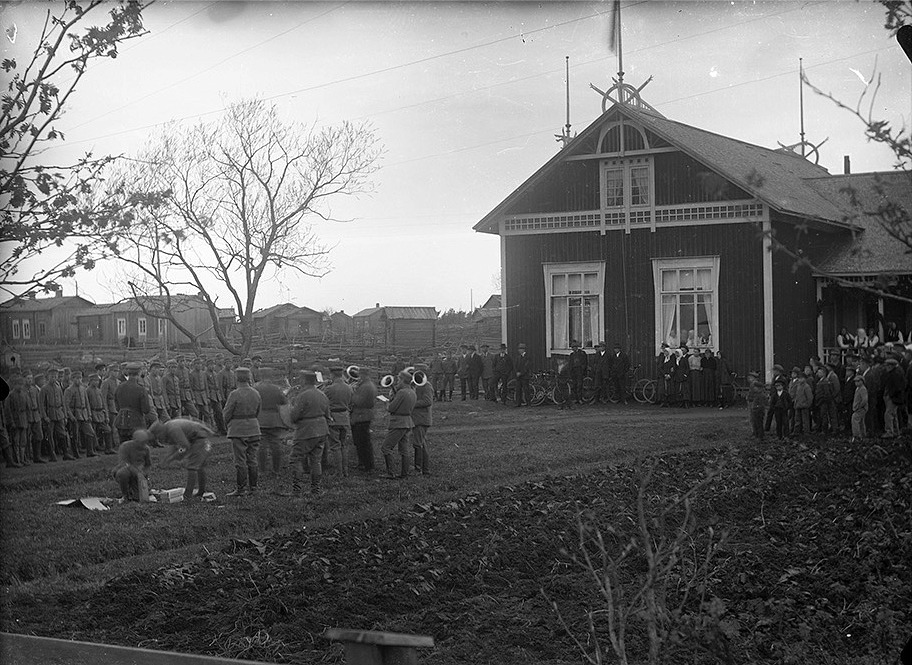 Skyddskårister uppställda på ungdomsföreningens gårdsplan. Till höger föreningshuset Majbo som invigdes 1910. Notera den stora mängden byggnader tillvänster uppe på Byåsen.