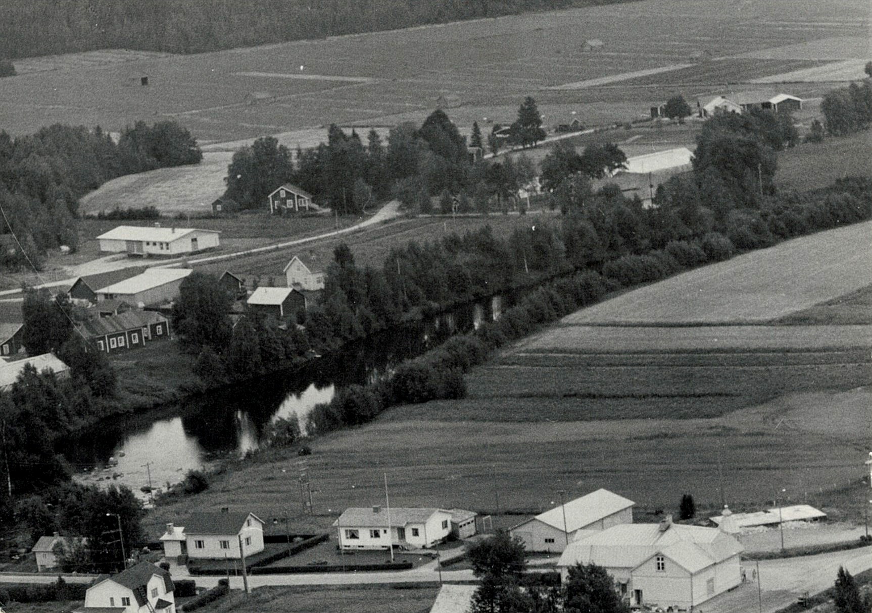 På flygfotot från 1972 syns Backlundas gamla gård till vänster på A-sidon. Bakom gården syns Lappfjärds Potatis förpackningshall som byggdes 1965 och till höger om den Nylundas-Idas lillstuga. Längst nere till höger syns husgrunden till det nedbrunna sparbankshuset.