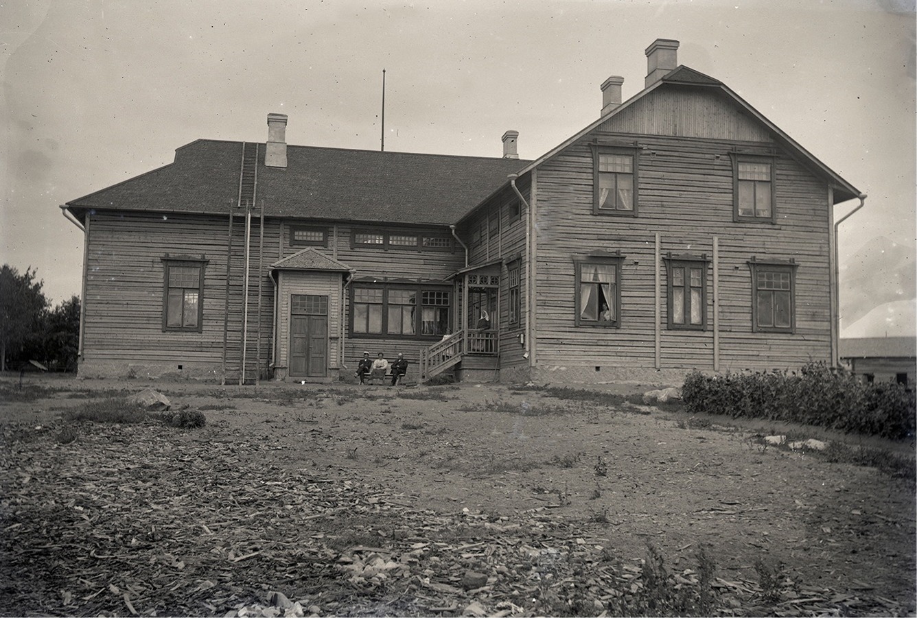 En del av lärarfamiljen Wadström utanför det nya skolhuset, där spånorna fortfarande ligger på skolgården.