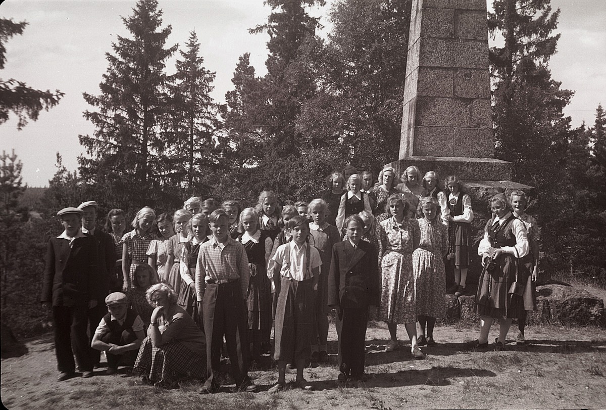 Lantbruksklubbens medlemmar framför minnesstenen över de stupade i Finska kriget 1808-09, som finns i Oravais. Fotot från 1950.