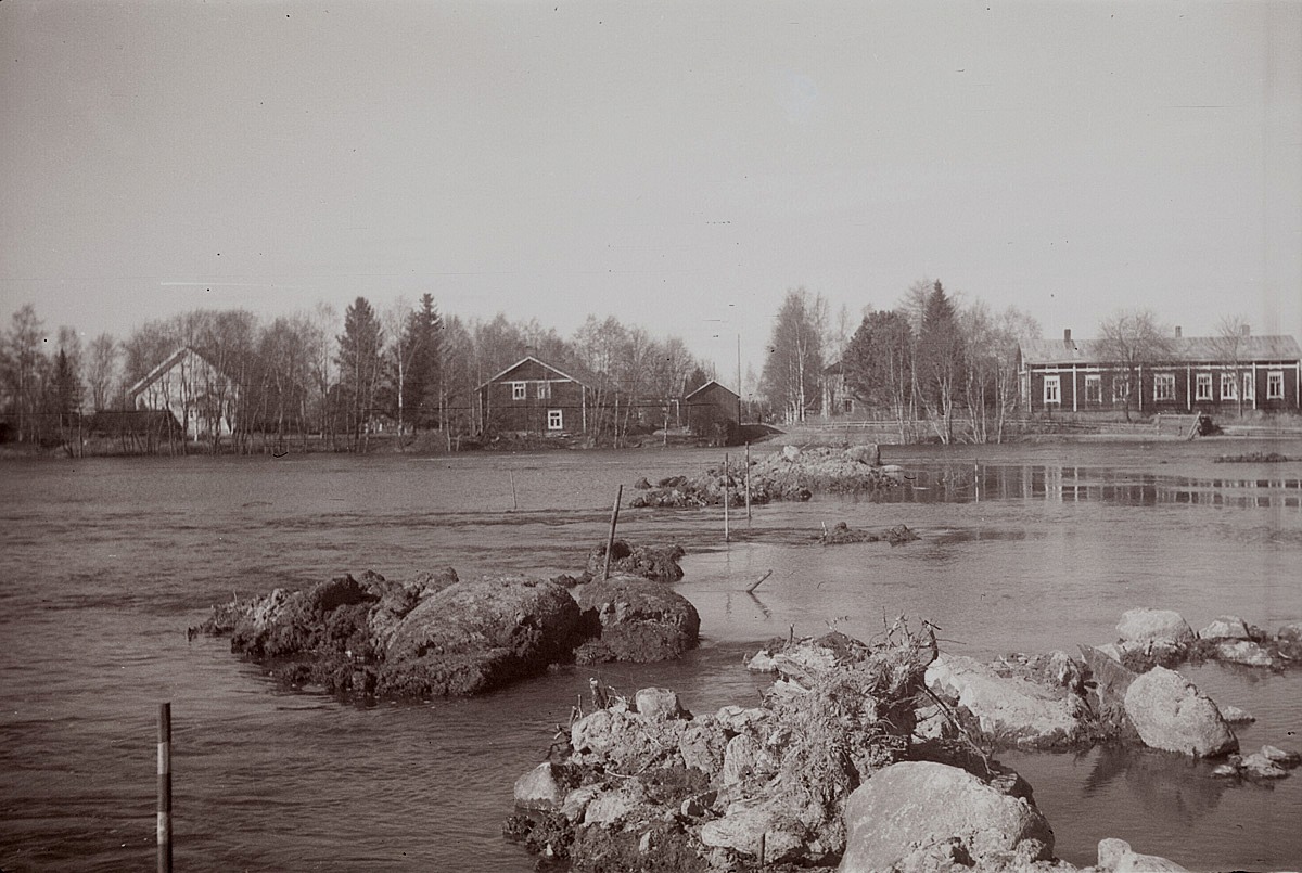 Vårfloden i Lappfjärds å 1956. Till vänster Helsingforsbanken, i mitten garvare Stenmans gård och till höger lantmätare Molanders gård. Den kommande brobanken till Centralbron är utstakad i ån.