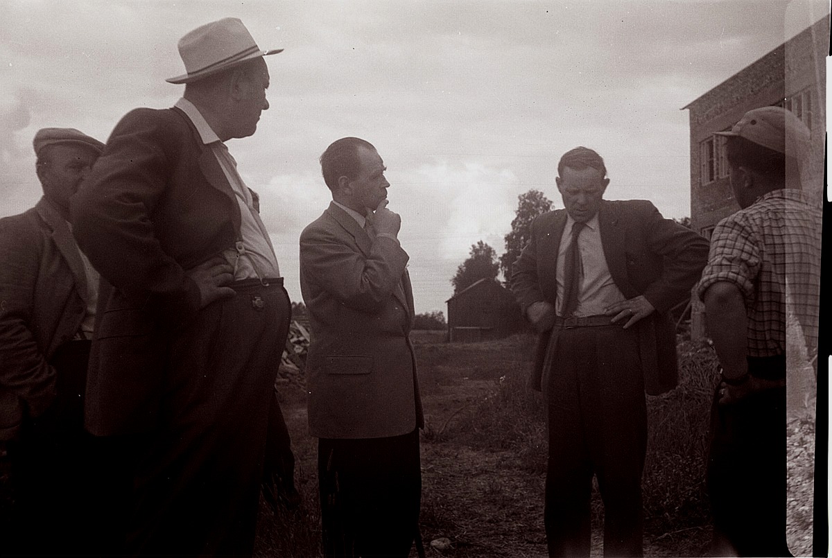 Kommunens män diskuterar bygget av Centralskolan med byggarna. I bakgrunden syns Jakob af Hällströms häbbre.