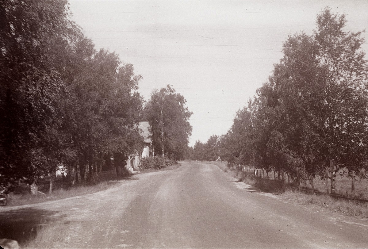 "Svedarbacken" nedanför kyrkan där korsningen till Bagar-Linas tå syns till vänster. Gården mitt i bild är "Kaaljohanas" alltså Ch. Ulfves affärshus. Björkarna till höger planterade eleverna under åren 1930-1932.