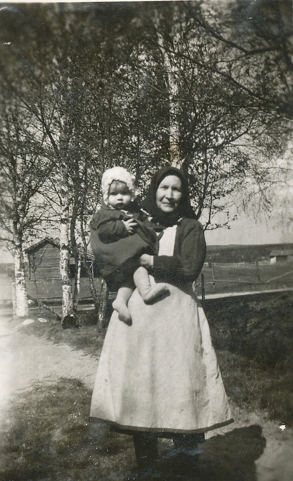 Selma Granholm på gården med barnbarnet Inger i famnen, år 1943. 