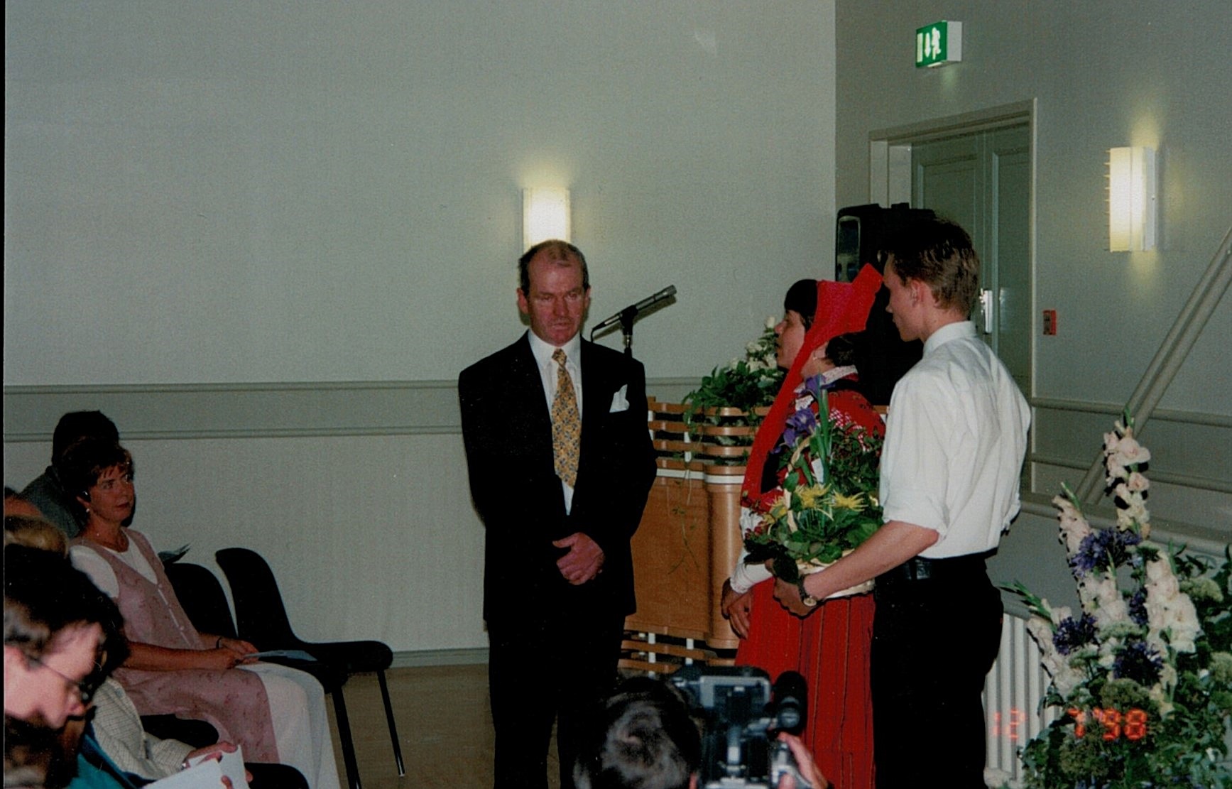 Kurt Backlund som under byggnadstiden fungerat som byggnadskommitténs ordförande blir uppvaktad med blommor på invigningsfesten av Åsa Ekman och Niklas Rosengren.