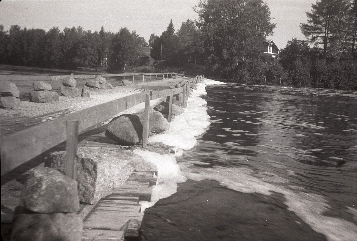 Stora stenar lastades på Gamla bron så att den inte skulle åka iväg med de strida vattenströmmarna sommaren 1961. Molanders gård syns bakom buskarna-