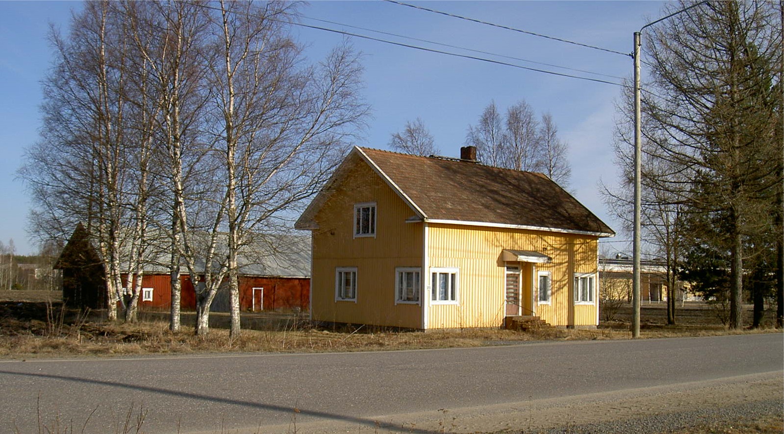 Eskil Rosenbacks gård fotograferad från norr år 2003. Till vänster om uthuset skymtar växthusen på Mellanå Plant och i högra kanten syns Estrellas fabriksbyggnader.