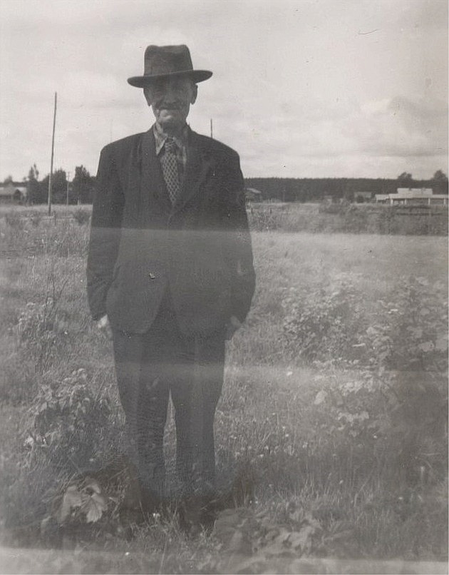 Erland Grönroos (1882-1963) står nära Lillsjövägen, med gårdarna i Palon i bakgrunden.