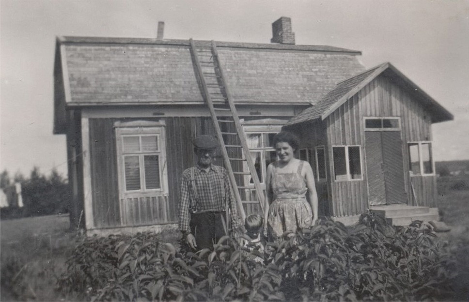 Någon gång runt 1950 flyttade ingången från gaveln i norra ändan till långsidan mot öster. Här står Erland Grönroos tillsammans med sonhustrun Helga och lilla Ove framför gården.