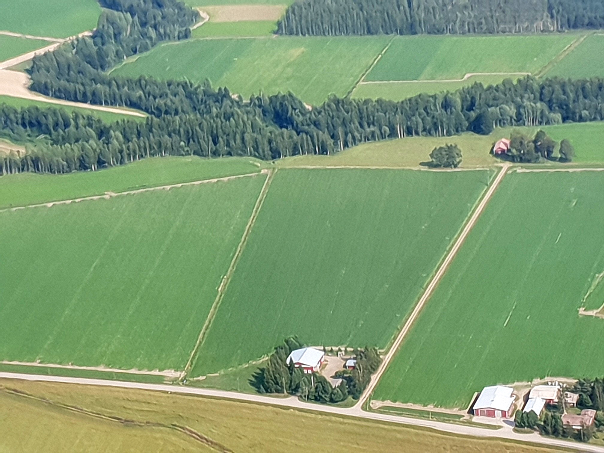 Här ser vi att åkrarna är stora på Åbackan och att det är långt mellan gårdarna. Uppe till höger bakom träden finns Lindfors gamla gård och nere i mitten finns Lindfors nya gård. Nere i högra hörnet syns Kauko Santamäkis gårdsgrupp. 