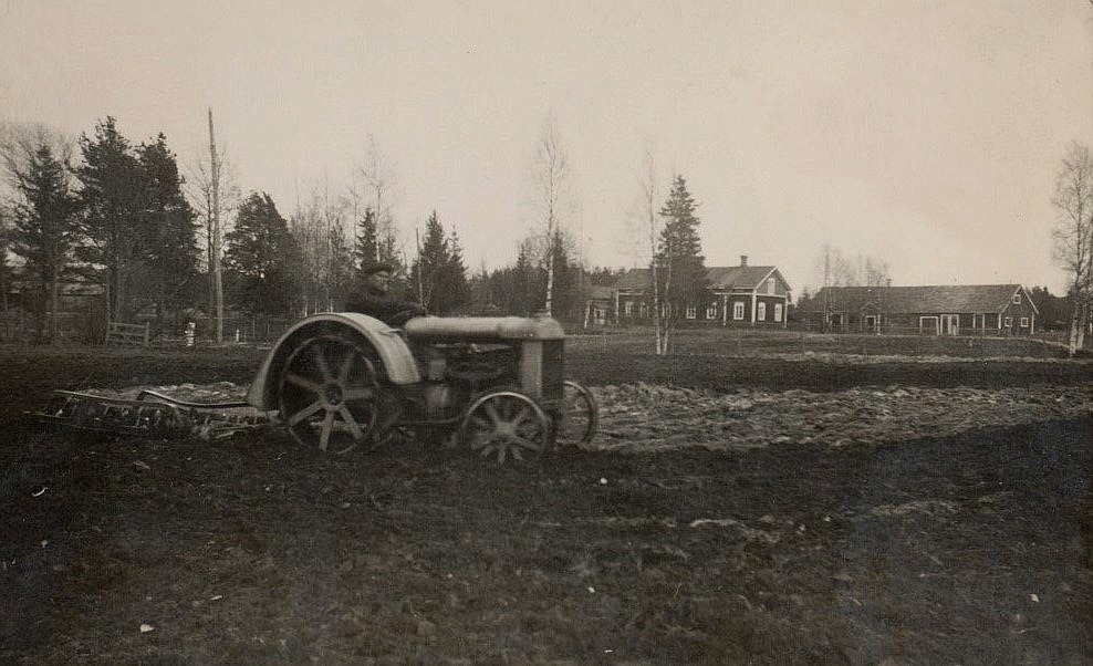 På Viktor Nylunds foto så håller Lennart Grans på och harvar åkern hos Nylundas. I bakgrunden Nylundas gamla gård och uthusen som syns, står fortfarande kvar.